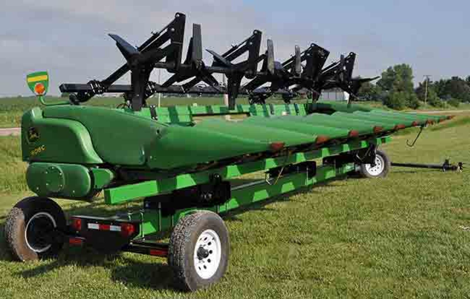Crop sweeper on combine head trailer
